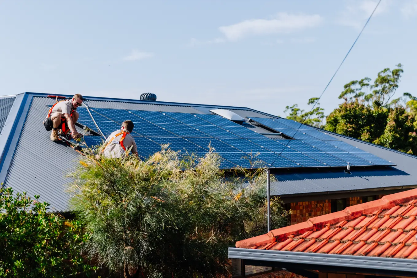 Two Gecko installers fitting solar panels on a Coffs Coast home