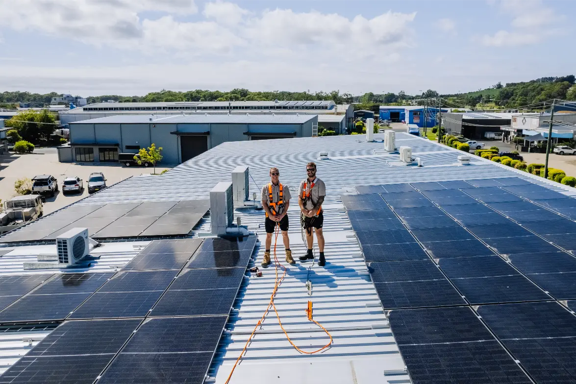Matty and Jordan installing panels on a rooftop